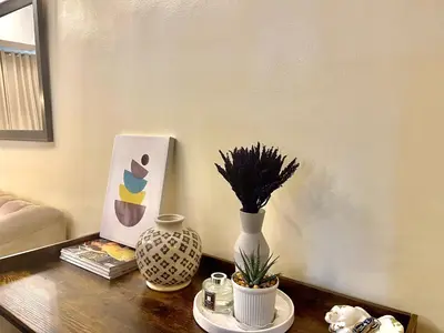 a table with two vases and a painting on it at Cozy Place @ Venice Luxury Residences in Manila