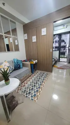 a living room with a couch and a table and a rug at VGC Crib in Manila
