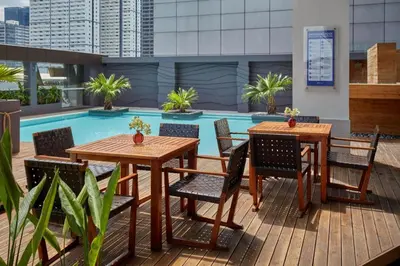 a patio with tables and chairs next to a pool at F1 Hotel Manila in Manila
