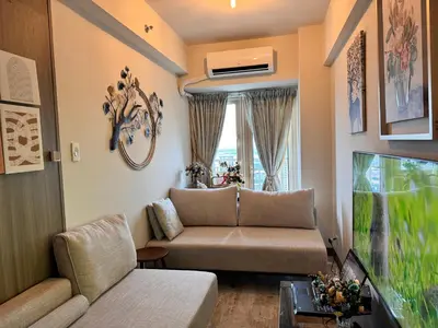 a living room with a couch and a large window at Penthouse Lvl Luxury Cndo Nr MOA in Manila