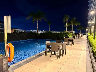 a patio with a table and chairs next to a swimming pool at Penthouse Lvl Luxury Cndo Nr MOA in Manila