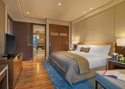 a bedroom with a large bed and a flat screen tv at Ascott Bonifacio Global City Manila in Manila