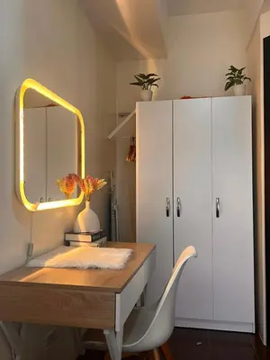 a desk with a mirror and a white cabinet at Kasara Resort Condotel by Vhi in Manila