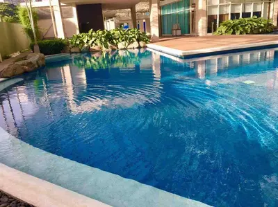 a large swimming pool in a building with blue water at Kasara Resort Condotel by Vhi in Manila