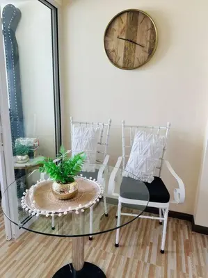 a room with a glass table and chairs and a clock at Azure Urban Resort - St Tropez Tower Staycation Unit with a European Touch in Manila