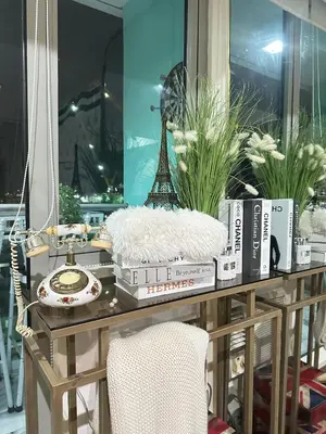 a table with books and a telephone and a tower at Azure Urban Resort - St Tropez Tower Staycation Unit with a European Touch in Manila