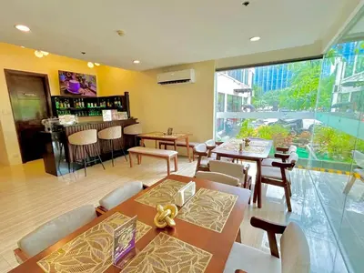 a restaurant with tables and chairs and a bar at 88 Courtyard Hotel in Manila