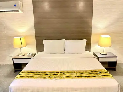 a bedroom with a bed and two lamps on tables at 88 Courtyard Hotel in Manila