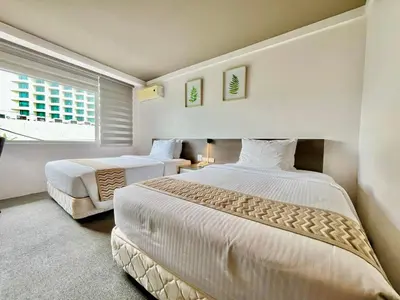 a bedroom with two beds and a window at 88 Courtyard Hotel in Manila