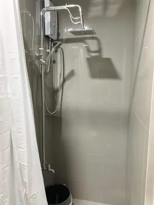 a shower in a bathroom with a shower curtain at Cozy 1-BR Flat in Air Residences Makati in Manila