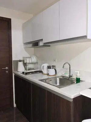 a kitchen with a sink and a counter top at Cozy 1-BR Flat in Air Residences Makati in Manila