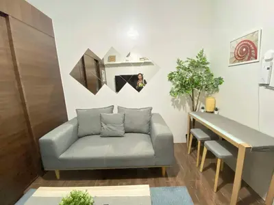 a living room with a couch and a table at Cozy 1-BR Flat in Air Residences Makati in Manila