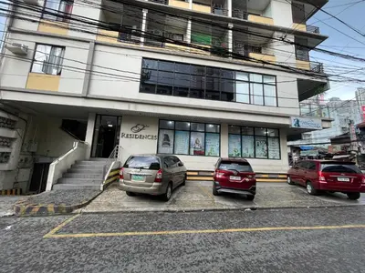 two cars parked in a parking lot in front of a building at Eco Friendly Studio Rooms Edsa Mandaluyong Shaw at F Residences under New Management in Manila