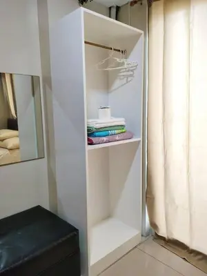 a white closet with some towels and a mirror at Magayon Staycation Shell Residences Mall of Asia in Manila