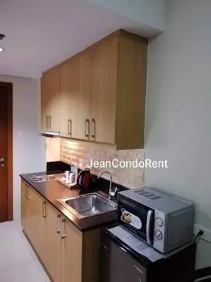 a kitchen with a sink and a microwave at Magayon Staycation Shell Residences Mall of Asia in Manila
