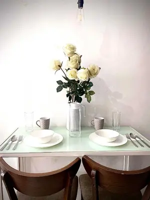 a table with two plates and a vase of roses at Buenbyahe Rooms Studio Type Mandaluyong Edsa Shaw MRT Studio at F Residences Under new management in Manila