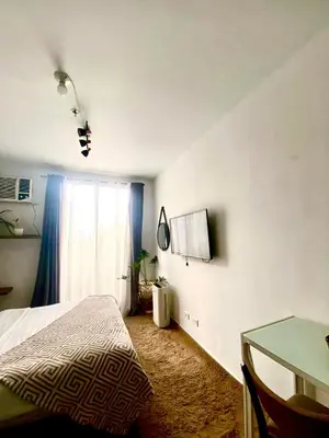 a bedroom with a bed and a table and a window at Buenbyahe Rooms Studio Type Mandaluyong Edsa Shaw MRT Studio at F Residences Under new management in Manila