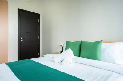 a bed with green and white sheets and towels on it at 2BR 2TB Uptown Parksuites BGC Balcony,fast WiFi,Washer in Manila