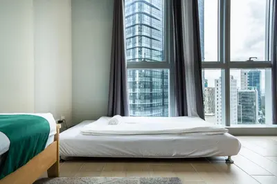 a bedroom with a bed and a large window at 2BR 2TB Uptown Parksuites BGC Balcony,fast WiFi,Washer in Manila