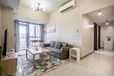 a living room with a couch and a table at 2BR 2TB Uptown Parksuites BGC Balcony,fast WiFi,Washer in Manila