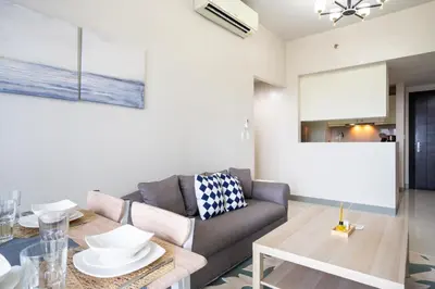 a living room with a couch and a table at 2BR 2TB Uptown Parksuites BGC Balcony,fast WiFi,Washer in Manila