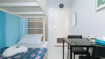 a bedroom with a bed and a desk and a bed and a table at Catlea Inn in Manila