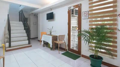 a room with a table and a chair and a staircase at Catlea Inn in Manila