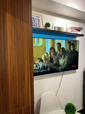 a flat screen tv hanging on a wall at Prime Posh Downtown Condo in Manila
