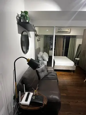a room with a couch and a bed with a mirror at Prime Posh Downtown Condo in Manila