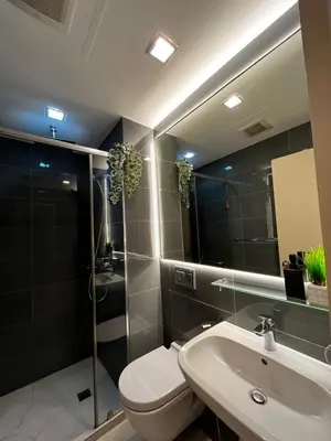 a bathroom with a toilet and a sink and a mirror at Prime Posh Downtown Condo in Manila