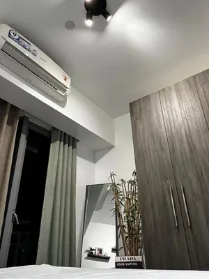 a bedroom with a ceiling fan and a mirror at Prime Posh Downtown Condo in Manila