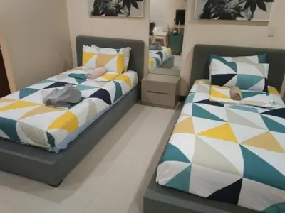two beds sitting next to each other in a room at Twin Beds Studio Room with City View in Manila