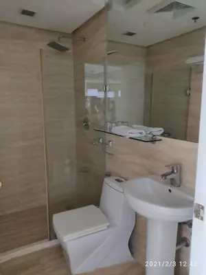 a bathroom with a toilet and a shower and a sink at Twin Beds Studio Room with City View in Manila