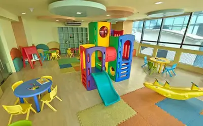 a room with a play area with tables and chairs at Twin Beds Studio Room with City View in Manila