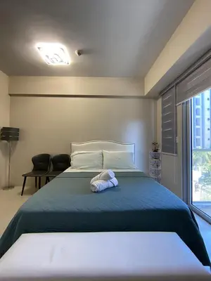 a bedroom with a bed with a stuffed animal on it at Palm Tree Villas in Manila