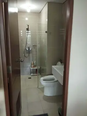 a bathroom with a toilet and a glass shower at Palm Tree Villas in Manila