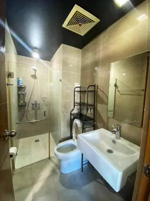 a bathroom with a white sink and a toilet at Palm Tree Villas in Manila