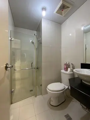 a bathroom with a shower and a toilet and a sink at Palm Tree Villas in Manila