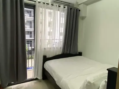 a bedroom with a bed and a window at SHORE RESIDENCE D16 shortwalk Mall of asia near airport in Manila