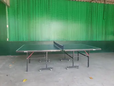 a ping pong table in front of a green wall at MaClare Resort in Imus
