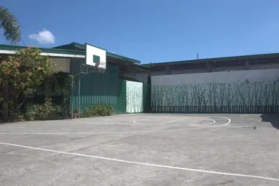 a basketball court in front of a building at MaClare Resort in Imus