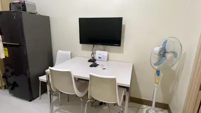 a room with a white table with chairs and a fan at CHATEAU ELYSEE A16 Near Resto And Sm Mall/Airport in Manila