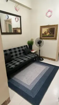 a living room with a couch and a blue rug at CHATEAU ELYSEE A16 Near Resto And Sm Mall/Airport in Manila