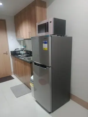 a kitchen with a stainless steel refrigerator with a microwave at 1Bedroom Cozy Condo near MOA in Manila