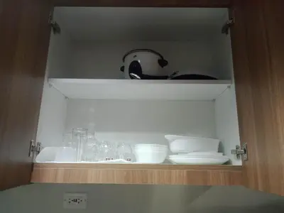 a cupboard with plates and other dishes in it at 1Bedroom Cozy Condo near MOA in Manila