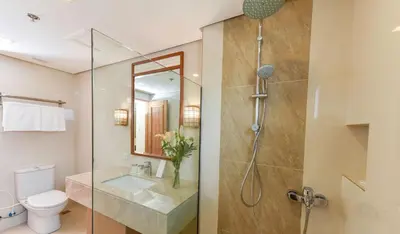 a bathroom with a shower and a toilet and a sink at Kabayan Hotel Pasay in Manila