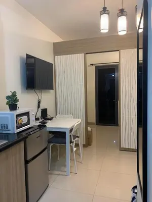 a kitchen with a table and a small kitchen with a table and chairs at SHORE RESIDENCE D17 shortwalk Mall of asia near airport in Manila