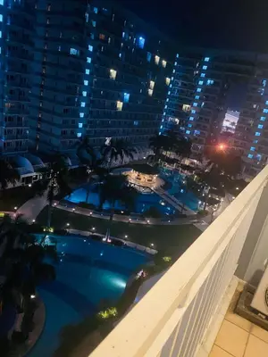 a view of a swimming pool at night at Shell Residences C21 Shortwalk Sm Mall Of Asia Airport in Manila