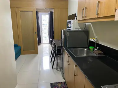 a small kitchen with a sink and a refrigerator at Shell Residences C21 Shortwalk Sm Mall Of Asia Airport in Manila