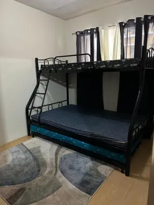 two bunk beds in a room with a rug at B-G Sorento Oasis 2BR in Manila